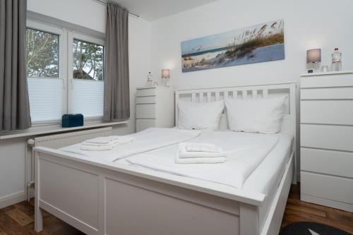 埃默尔斯比尔－霍斯比尔Ferienwohnungen Haus Schau ins Land nah an der Nordsee的白色卧室配有白色床和毛巾