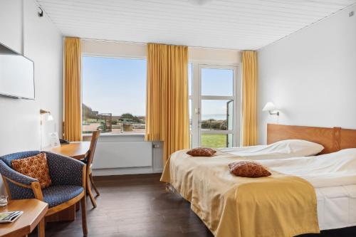 格林哥里皮奈霍斯酒店的酒店客房设有两张床、一张书桌和一个窗户。