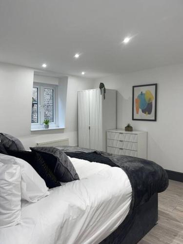 亨廷登Abacus House - TWO Bedroom Apartment的一间卧室配有一张带白色床单的大床