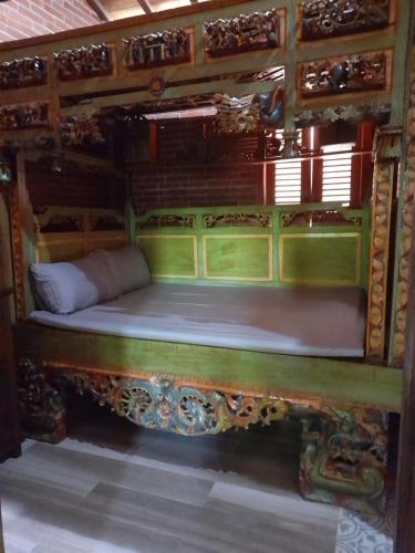 KaranganyarKrobyongan staycation kalaras的木架客房内的一张床位