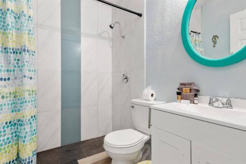 蓬塔戈尔达Waterfront Condo #9的一间带卫生间、水槽和镜子的浴室