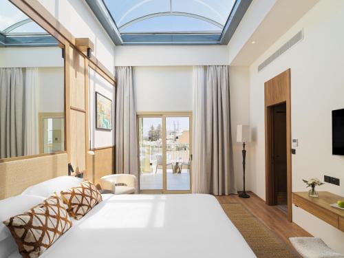 拉纳卡Leonardo Boutique Hotel Larnaca的卧室设有一张白色大床和一扇窗户。