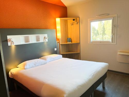 卡尔卡松卡尔卡松赛特宜必思快捷酒店的一间卧室配有一张白色大床和橙色墙壁