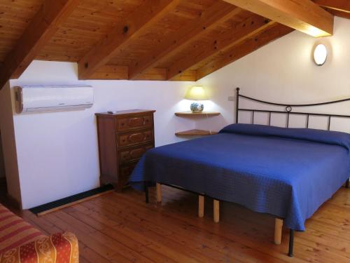 Grazzano BadoglioHoliday Home Le Rose Rosse by Interhome的一间卧室设有蓝色的床,铺有木地板。