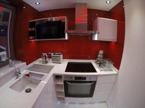 伦敦Perfect Central London Base的厨房设有红色的墙壁和炉灶。 顶部烤箱