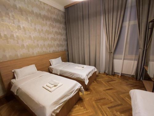 库塔伊西Cozy Apartment In Old Town Kutaisi的酒店客房设有两张床和窗户。
