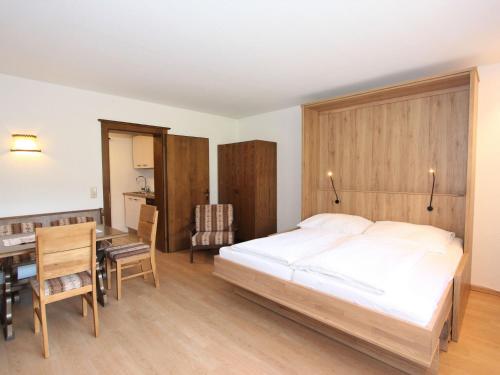 菲根Apartment Römerhof-5 by Interhome的一间卧室配有一张床、一张桌子和一张桌子