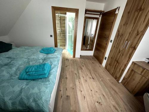 哈茨山区黑尔茨贝格Haus an der Sieber Zimmer 5的一间卧室配有一张蓝色床单,铺有木地板