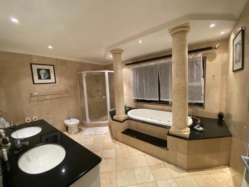 布鲁堡史特兰Imany Guest House的浴室配有两个盥洗盆和浴缸。