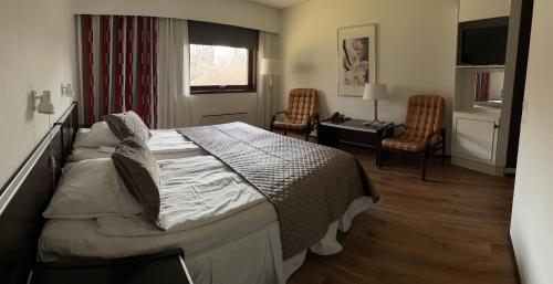 埃克勒伊克罗餐厅酒店的卧室配有一张床、一张桌子和椅子