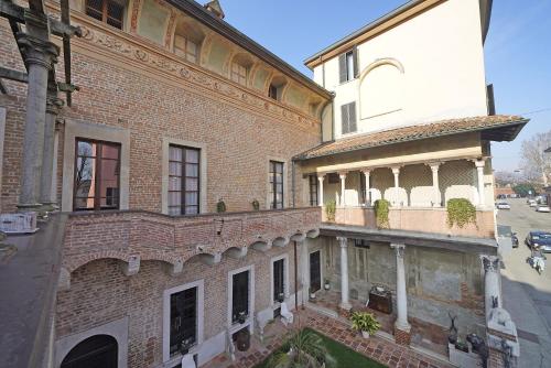 克雷莫纳Foresteria Palazzo Guazzoni Zaccaria的街道上一座旧砖砌建筑,设有阳台