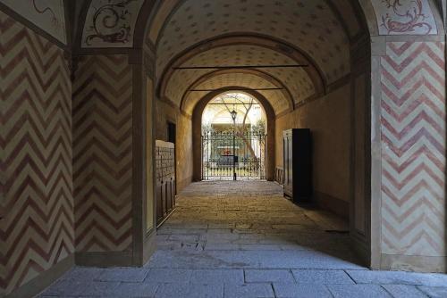 克雷莫纳Foresteria Palazzo Guazzoni Zaccaria的建筑中带拱门的走廊