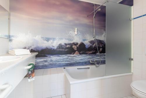 卡兰茨奥赫卡兰茨奥赫弗莱彻酒店的浴室内有一幅波浪画