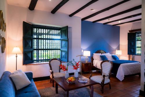 波帕扬Hotel Hacienda Supracafe的卧室配有一张床和一张桌子及椅子