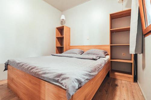 巴诺夫茨Terme Banovci - Mobilne hiške Med Brajdami的一间卧室配有一张带木制床头板和架子的床。
