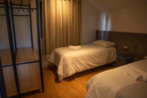 格拉玛多Cabana Serra Grande Sossego的一间卧室配有两张床和镜子