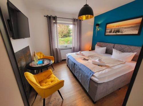 施塔德Hotel Schwedenkrone的一间卧室配有一张大床和一张黄色椅子