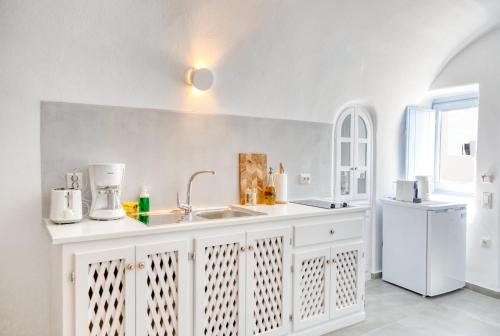 伊亚阿瑞斯卡芙斯酒店的白色的厨房设有水槽和白色冰箱