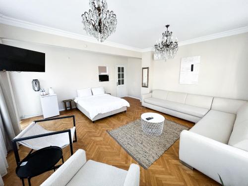 伯萨Avlu Tophane的客厅配有白色家具和吊灯。
