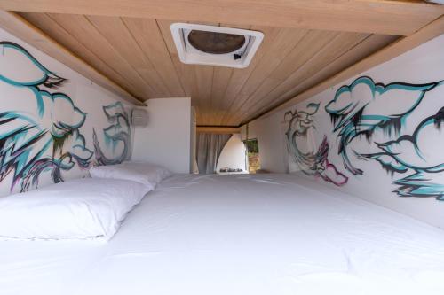 圣胡安Vive La Van的卧室配有两张壁挂涂鸦的床。