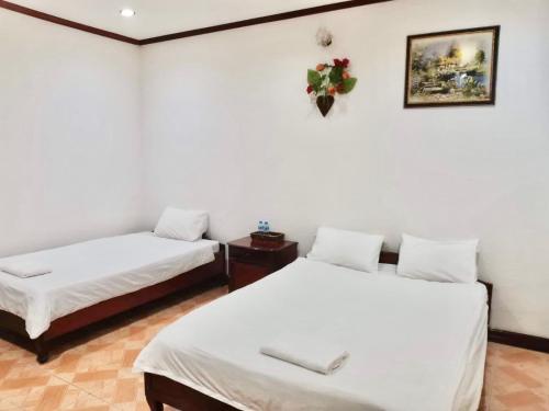 万象Mina Hotel的白色墙壁客房的两张床
