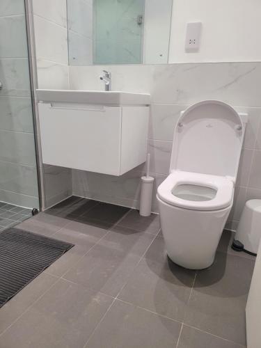 阿克拉RT PROPERTIES @ THE LENNOX AIRPORT RESIDENTIAL的浴室配有白色卫生间和盥洗盆。