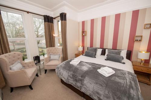 布里德灵顿Mont Millais的一间卧室配有一张大床、一把椅子和窗户。