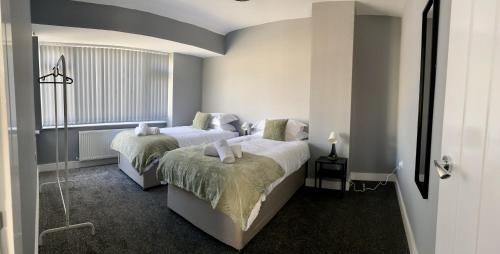 利兹Gateway Getaway in Horsforth Sleeps 7的一间卧室设有两张床和窗户。