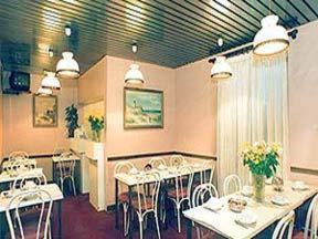 巴黎阿文尼尔酒店的一间设有白色桌椅的用餐室