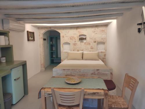 基莫洛斯岛Apanemo Beach House Agios Nikolaos Kimolos的配有一张床和一张桌子及椅子的房间