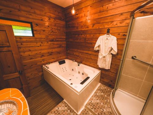 克萨尔特南戈Casa Morasan Hotel-Boutique的一间带浴缸的浴室和挂在墙上的衬衫