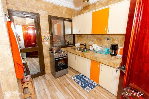 杜阿拉Clos d'Or, Appartements meublés Douala Makepé的一间小厨房,配有橙色和白色的橱柜