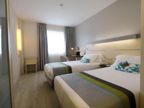 姆提瓦巴哈潘普洛纳快捷假日酒店的酒店客房设有两张床和窗户。