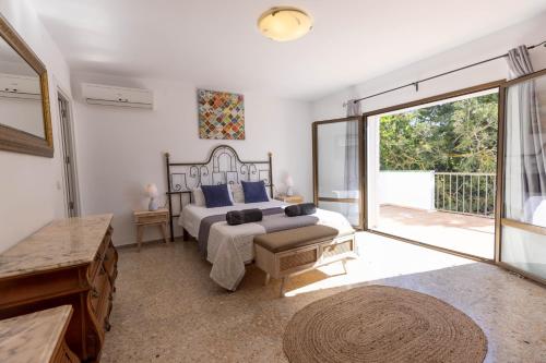 圣安东尼奥湾Villa Carvi的一间卧室设有一张床和一个大型滑动玻璃门
