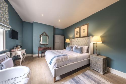 纽马基特帕库霍思宾馆的一间卧室设有蓝色的墙壁、一张床和一个浴缸