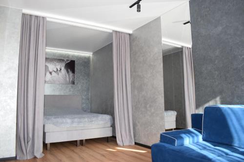 卢茨克Дизайнерські апартаменти в ЖК DreamTown 10б的一间卧室配有一张床和一张蓝色的沙发
