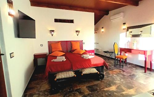 CampinhoAladin Comfort Country Rooms的一间卧室配有红色的床和一张书桌