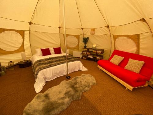 PentraethGlamping Red Wharf Bay的帐篷内的房间,配有一张床和一张沙发