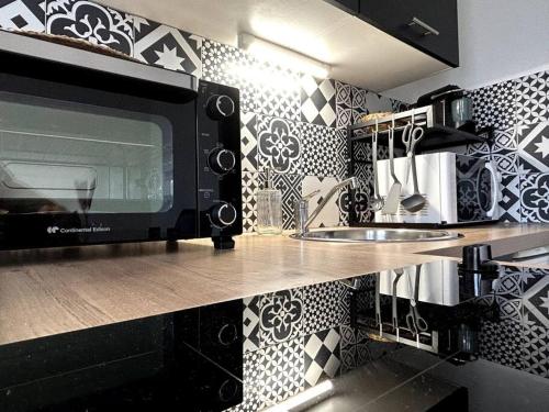 布尔日Logement Neuf - Proximité Centre的厨房在柜台上配有微波炉