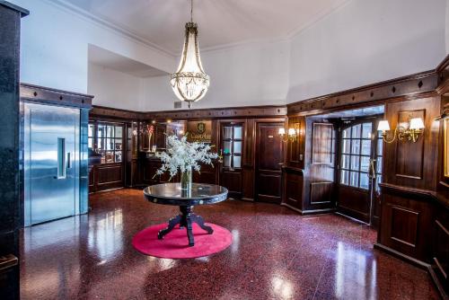 圣达菲Castelar Hotel Santa Fe的红色地毯上带鲜花桌的房间
