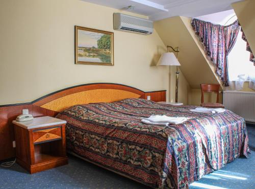 埃格尔奥菲哈兹酒店的酒店客房配有一张床铺和一张桌子。
