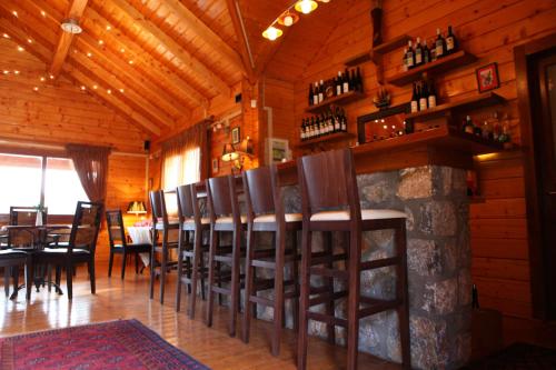 费内斯Pasithea Mountain Chalet的一间用餐室,内设一间酒吧,配有一束椅子