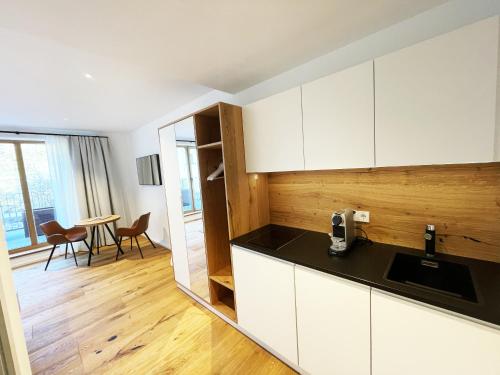 斯皮茨Weingut FJ Gritsch Mauritiushof Apartments的厨房配有白色橱柜和桌椅