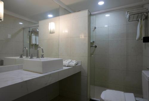 马塞约马塞约大西洋套房酒店的白色的浴室设有水槽和淋浴。