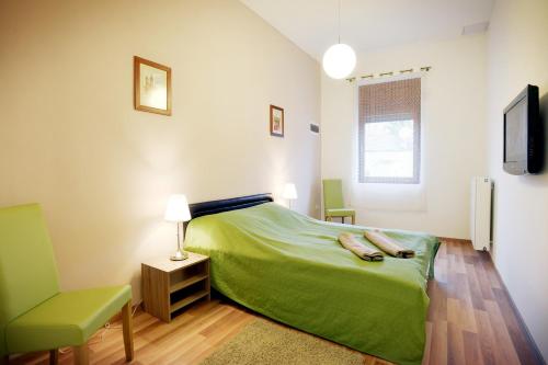 埃格尔埃格尔角落公寓的一间卧室配有绿色的床和椅子