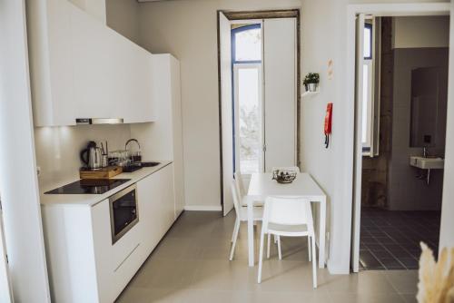 塞洛里库迪巴什图Estação Ferroviária de Lourido的白色的小厨房配有桌椅