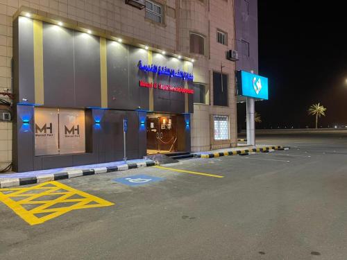 哈伊勒منازل الشمال للشقق المخدومة Manazel Al Shamal Serviced Apartments的夜间在大楼前的停车场