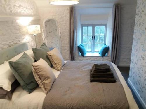 WhitwellThe Bake House (Berryl Farm Cottages)的卧室配有带枕头的大床和窗户。