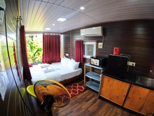 黎明之村Wow Farm House & Resort near Pondicherry的小房间设有一张床和一台电视机