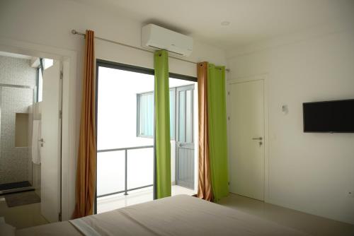 明德卢Duarte Apartments - Morabeza的一间卧室设有一张床和一个大窗户